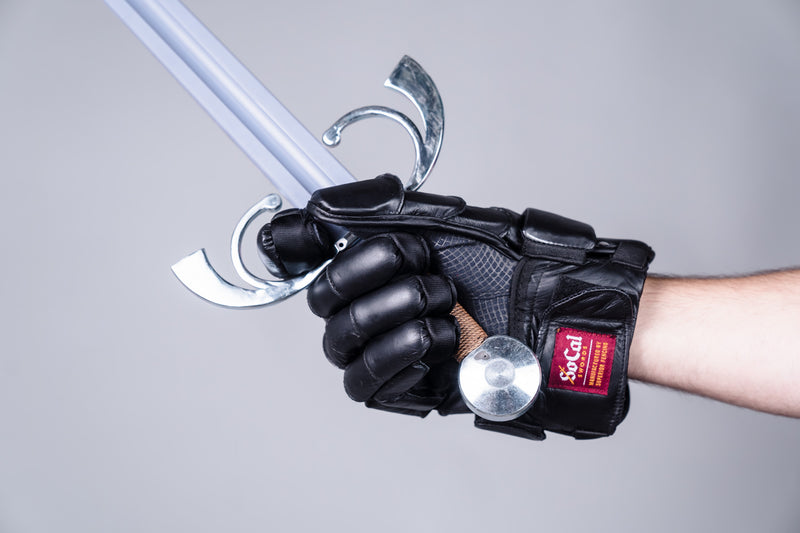 Padded lacrosse style glove being worn and gripping sword, palm view